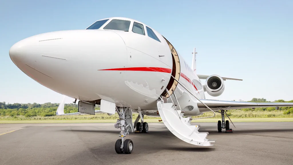 Sleek white Avcon Jet with open boarding stairs, featured aircraft on tarmac.